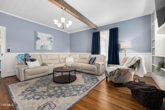 living area featuring beamed ceiling, a chandelier, ornamental molding, wood finished floors, and wainscoting
