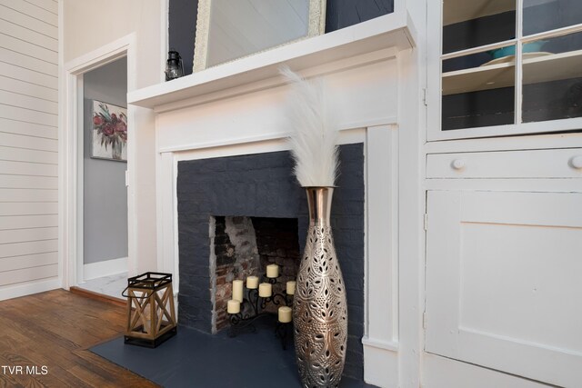 details featuring baseboards, wood finished floors, and a fireplace