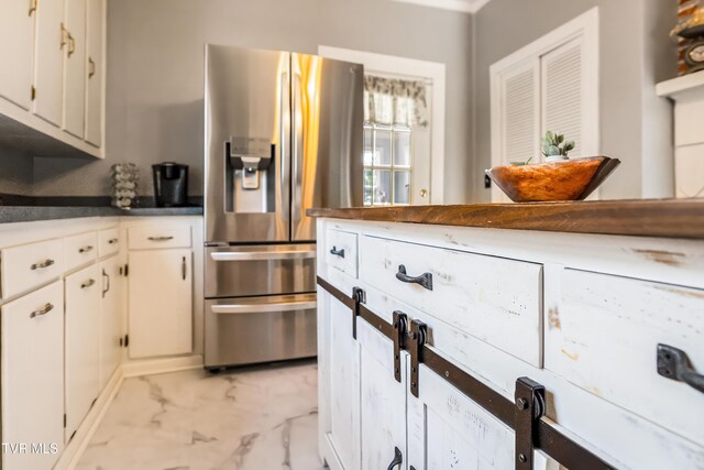 kitchen featuring white cabinets, stainless steel refrigerator with ice dispenser, and marble finish floor