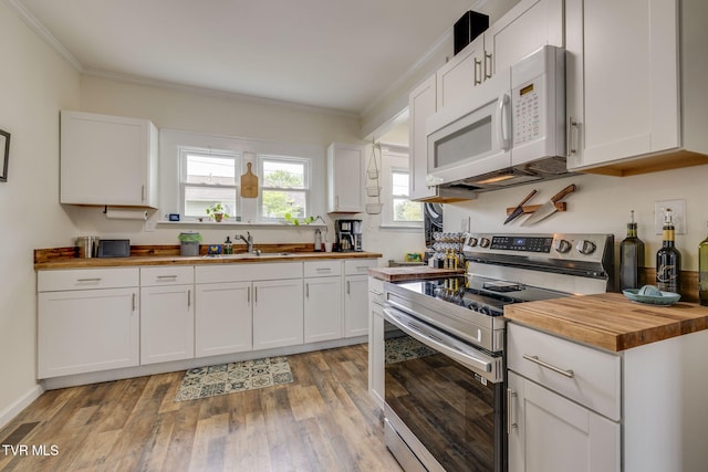 718 Wilson Ave, Johnson City, TN 37604 - kitchen featuring stainless steel electric range oven, a sink, wooden counters, ornamental molding, and white microwave