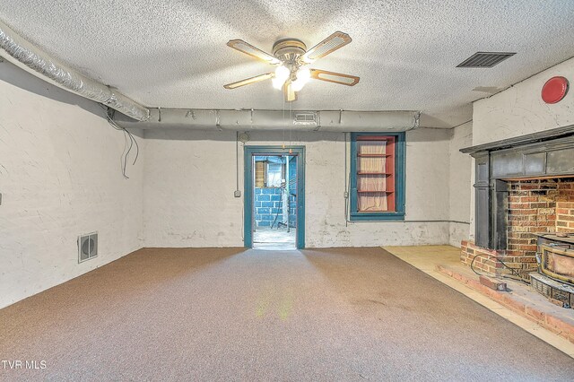 unfurnished living room featuring a textured wall, carpet, a textured ceiling, and visible vents