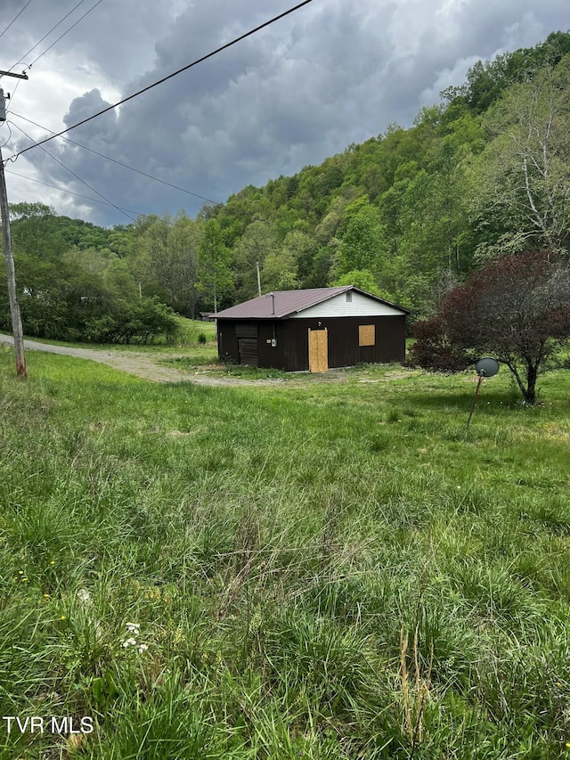 view of yard featuring an outbuilding and a view of trees
