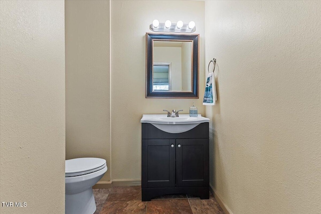 1902 Lamont St, Kingsport, TN 37664 - half bathroom with stone finish flooring, toilet, a textured wall, vanity, and baseboards
