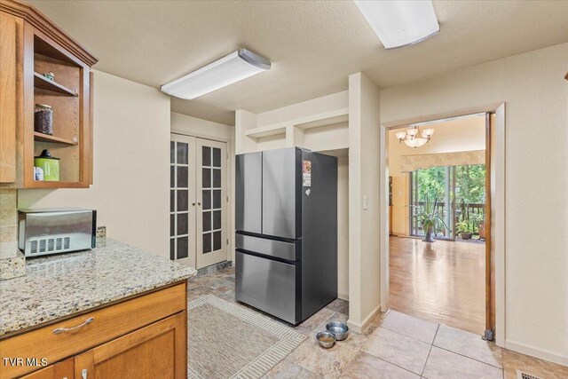 1902 Lamont St, Kingsport, TN 37664 - kitchen featuring light stone counters, open shelves, freestanding refrigerator, french doors, and a notable chandelier