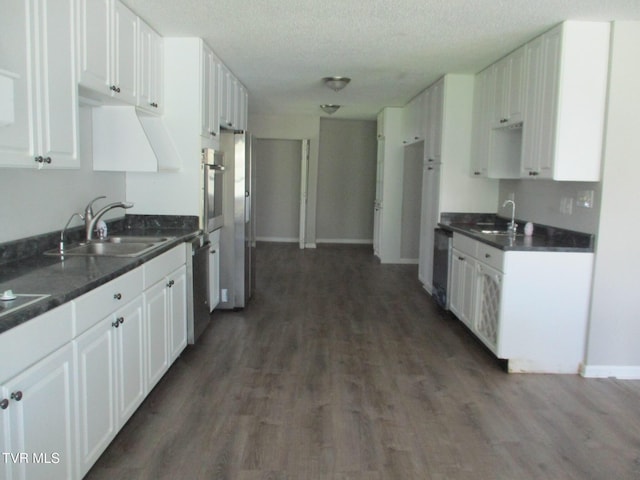 1209 Golf St, Bristol, TN 37620 - kitchen with dark countertops, a sink, white cabinets, and wood finished floors