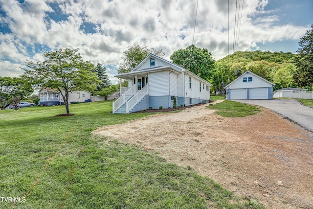 view of front facade with stairs, a garage, a porch, a front yard, and an outbuilding