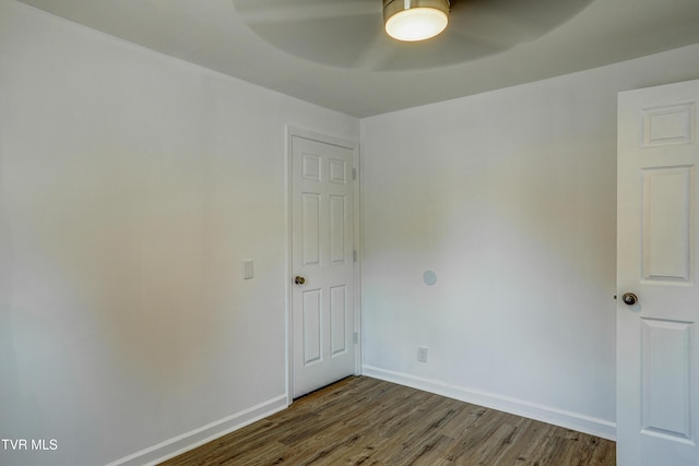 empty room featuring baseboards, ceiling fan, and wood finished floors