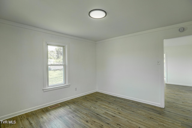 empty room with visible vents, baseboards, and wood finished floors