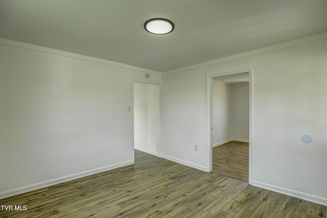 unfurnished room with baseboards and wood finished floors