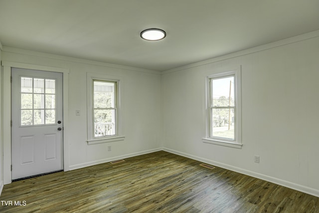 entrance foyer featuring dark wood-style flooring, baseboards, visible vents, and a healthy amount of sunlight