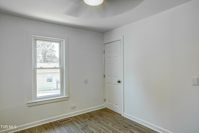 spare room featuring ceiling fan, baseboards, visible vents, and wood finished floors