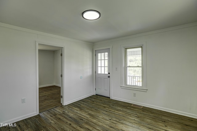 entryway featuring visible vents, dark wood-style flooring, crown molding, and baseboards