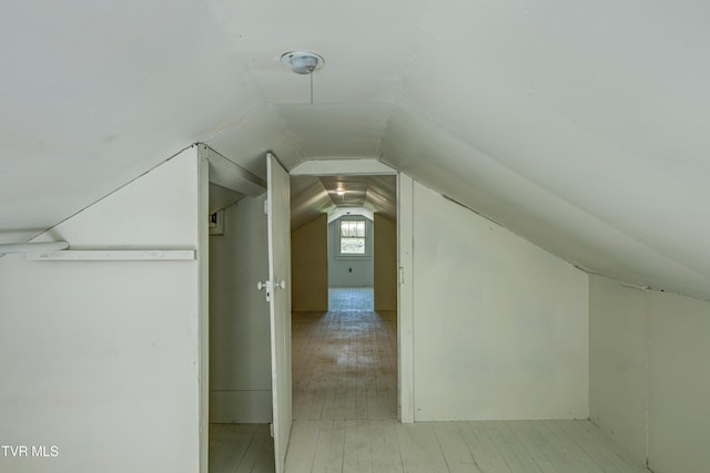bonus room with vaulted ceiling and light wood-style floors