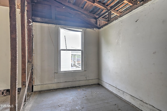 empty room with hardwood / wood-style flooring and vaulted ceiling