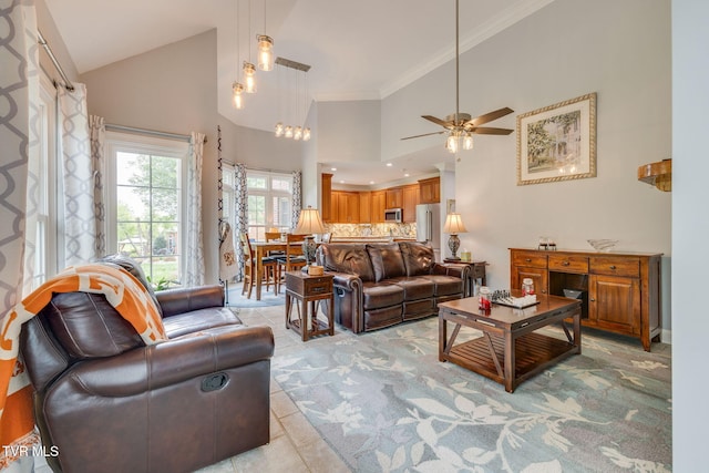 living room with light tile patterned floors, light colored carpet, ornamental molding, a ceiling fan, and high vaulted ceiling