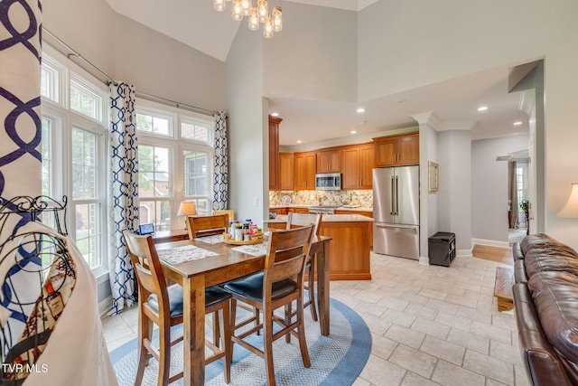 dining area with recessed lighting, an inviting chandelier, crown molding, baseboards, and a towering ceiling