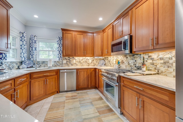 kitchen featuring light stone countertops, decorative backsplash, stainless steel appliances, ornamental molding, and a sink