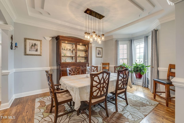 dining room featuring a raised ceiling, an inviting chandelier, and light wood-style flooring