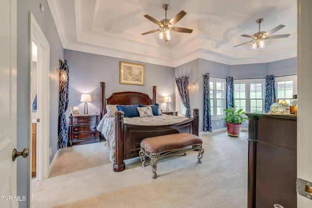 carpeted bedroom featuring ornamental molding, ceiling fan, and a tray ceiling