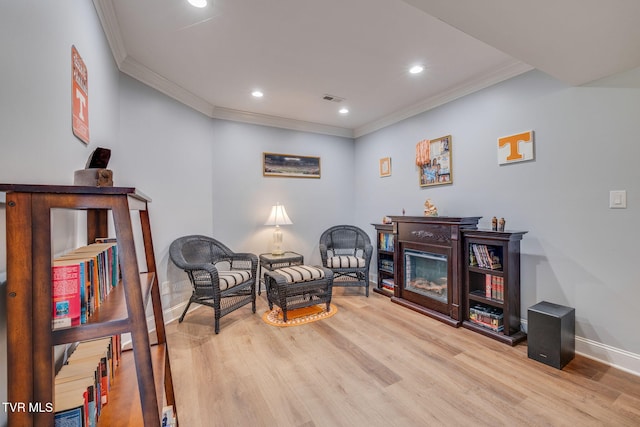 sitting room featuring crown molding, visible vents, baseboards, recessed lighting, and wood finished floors