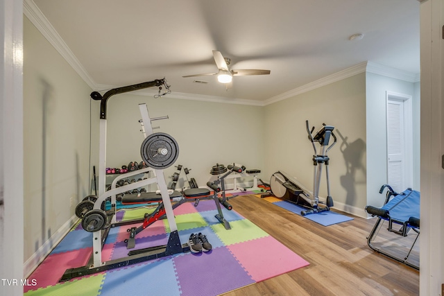 workout area with crown molding, ceiling fan, wood finished floors, and baseboards