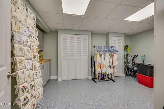 below grade area with a drop ceiling and baseboards