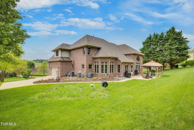 back of property with a lawn, central air condition unit, a gazebo, and brick siding