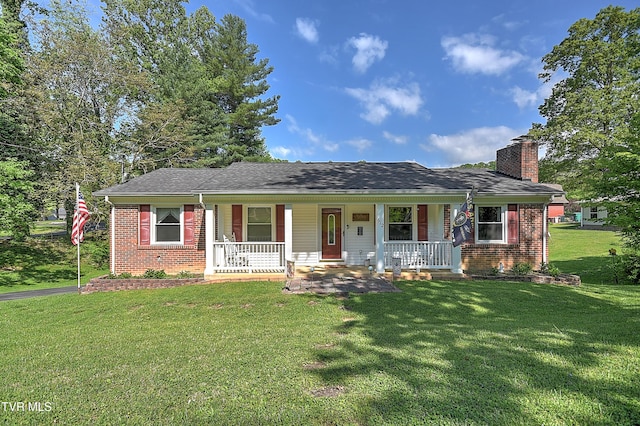 ranch-style home featuring a porch, brick siding, a chimney, and a front lawn