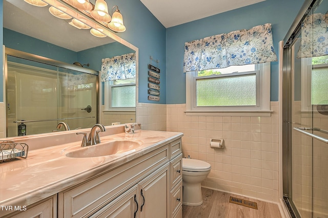 full bathroom featuring visible vents, a wealth of natural light, and tile walls