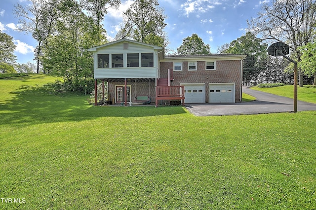 view of front of home featuring a garage, a front yard, brick siding, a sunroom, and driveway