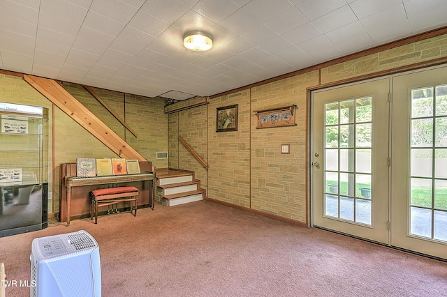 basement featuring a healthy amount of sunlight, carpet floors, and stairs