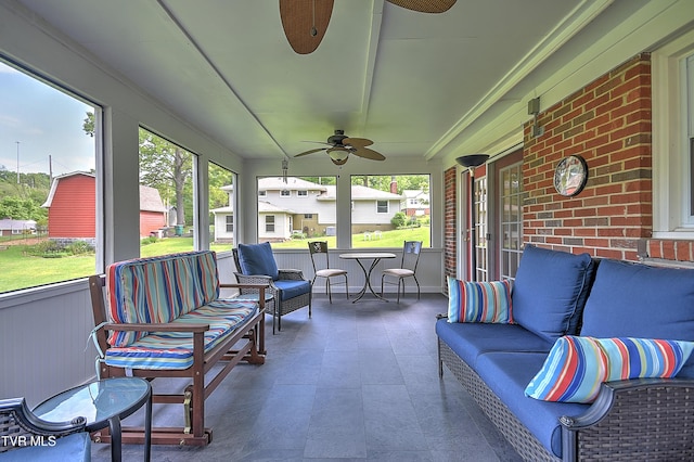 sunroom with ceiling fan and an outdoor living space