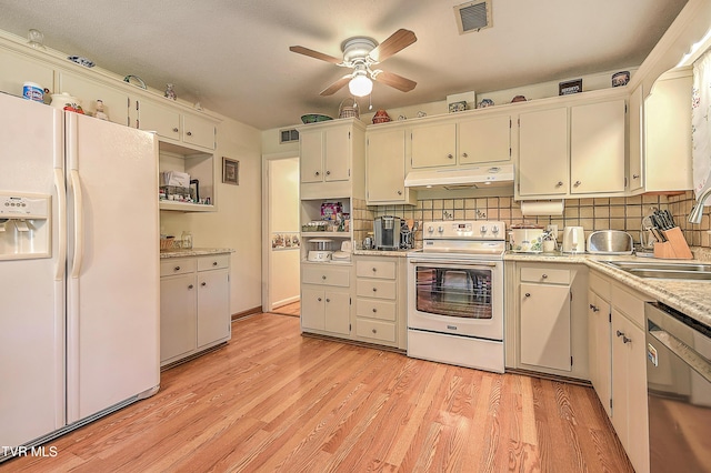 kitchen with visible vents, white appliances, light countertops, under cabinet range hood, and a sink