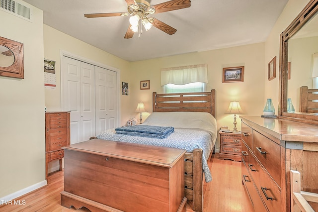 bedroom featuring a ceiling fan, visible vents, baseboards, a closet, and light wood finished floors