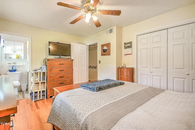 bedroom with connected bathroom, ceiling fan, light wood-style floors, visible vents, and a closet