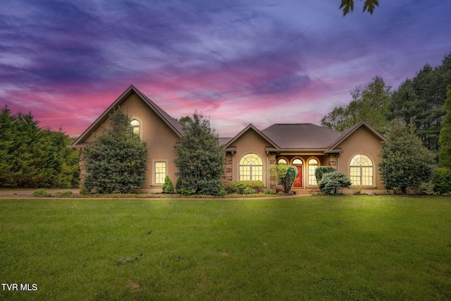 ranch-style home with stucco siding and a front lawn