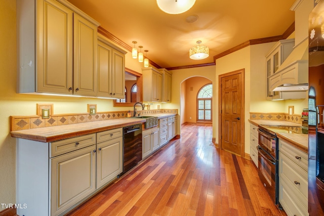 kitchen with light wood finished floors, wine cooler, range with two ovens, tile countertops, and arched walkways