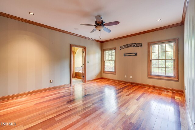 empty room with a ceiling fan, wood finished floors, a healthy amount of sunlight, and ornamental molding