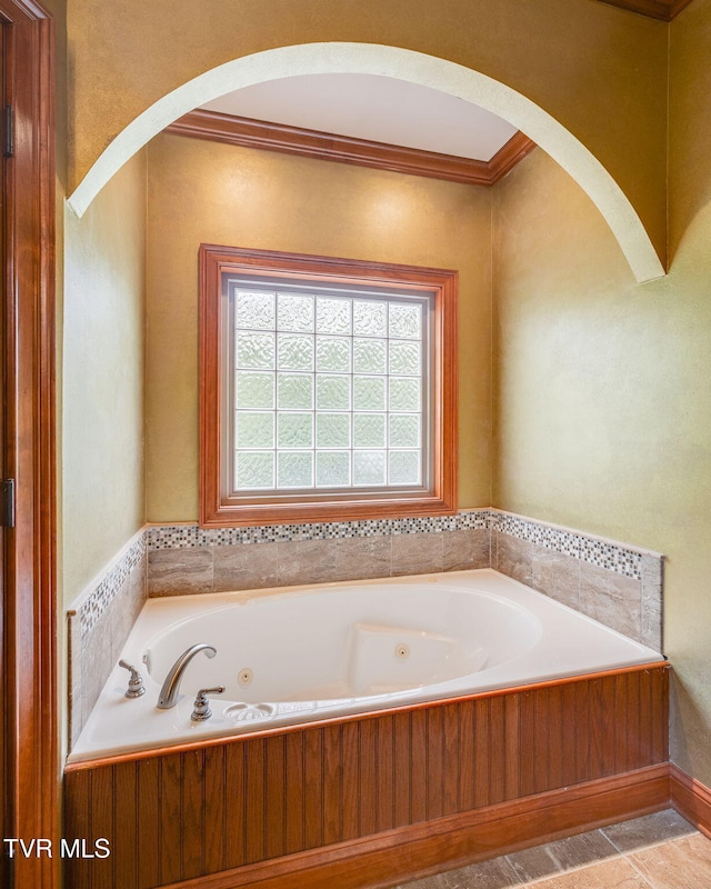 bathroom with a whirlpool tub and ornamental molding