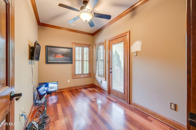 entryway featuring ceiling fan, hardwood / wood-style flooring, ornamental molding, and baseboards