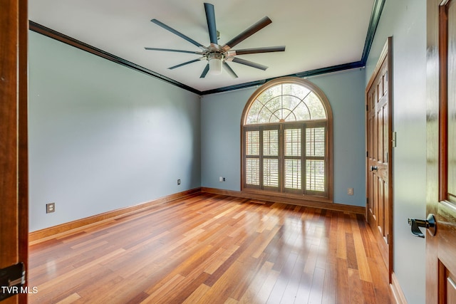 empty room with baseboards, a ceiling fan, light wood finished floors, and crown molding