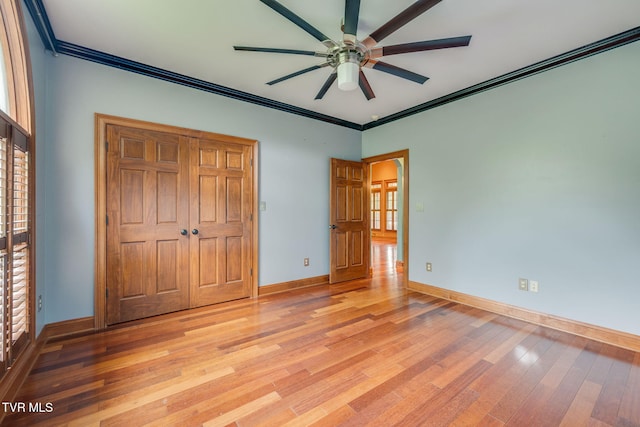 unfurnished bedroom featuring crown molding, a ceiling fan, light wood-style floors, and baseboards