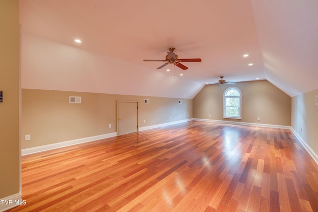 bonus room featuring light wood-style floors, ceiling fan, visible vents, baseboards, and lofted ceiling
