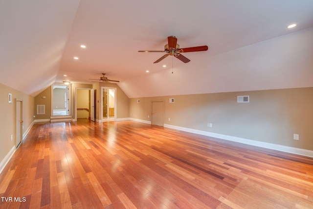 additional living space featuring light wood-style flooring, visible vents, ceiling fan, baseboards, and vaulted ceiling