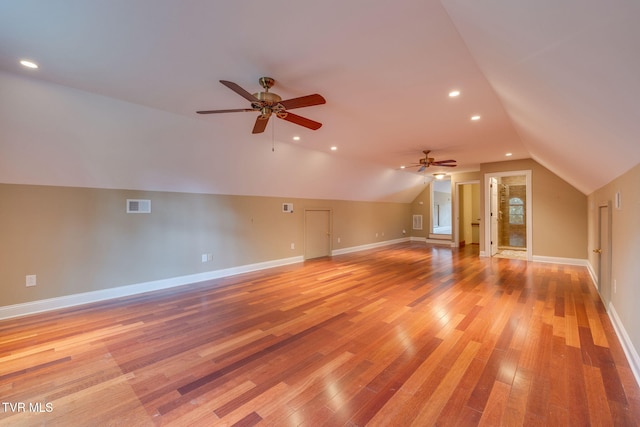 additional living space with visible vents, ceiling fan, light wood-type flooring, and vaulted ceiling
