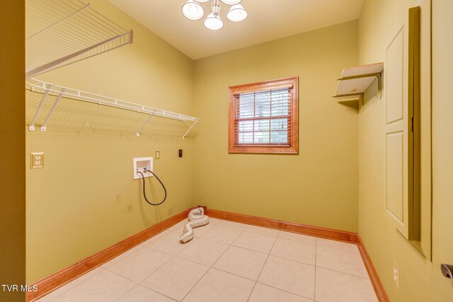 laundry room featuring a chandelier, light tile patterned flooring, laundry area, hookup for a washing machine, and baseboards