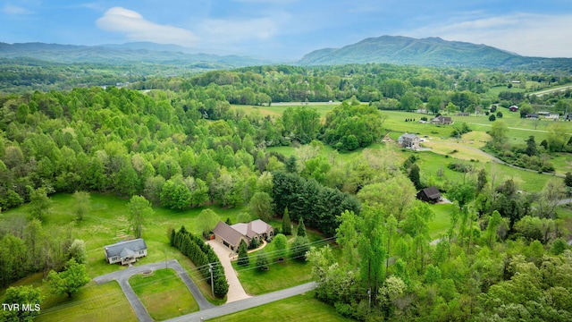 aerial view featuring a wooded view, a rural view, and a mountain view