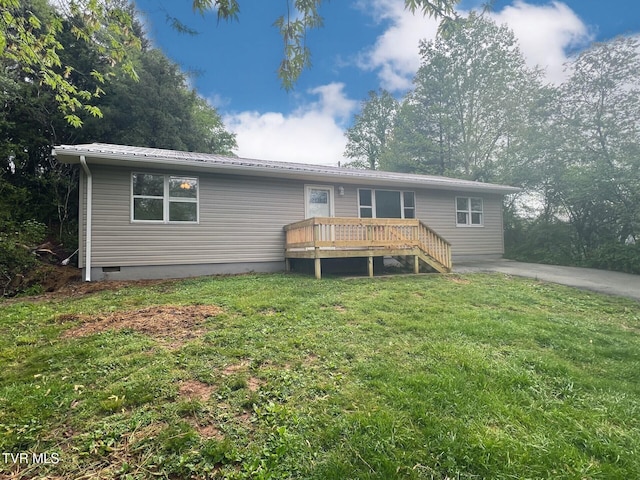 rear view of property with metal roof, a lawn, a wooden deck, and crawl space