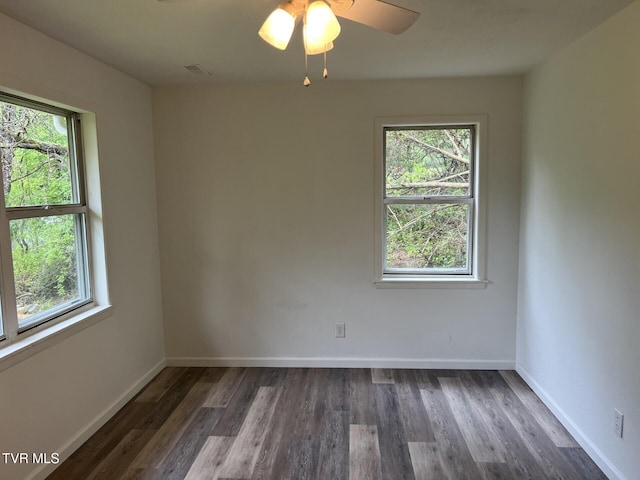spare room with wood finished floors, ceiling fan, visible vents, and baseboards