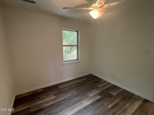 spare room with a ceiling fan, dark wood-style flooring, and baseboards
